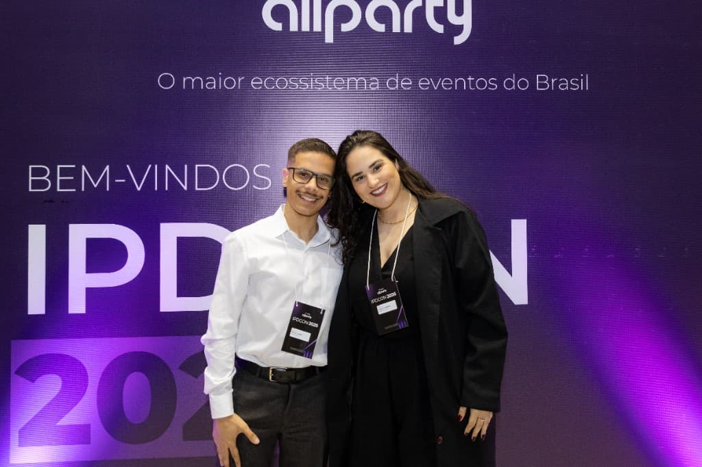 Recepção do IPDCON 2026 em frente ao painel do Grupo All Party